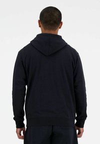 Felpa navy con tasca a marsupio, polsini e orlo a coste. Vestibilità standard con cappuccio regolabile e tessuto morbido. Vista posteriore mostrata.