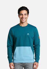 Felpa color teal con accenti azzurri, scollo rotondo e tasca a marsupio. Presenta un logo del marchio sul petto e un tessuto testurizzato.