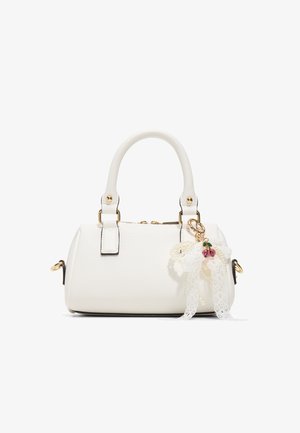 Sac à main blanc texturé avec des poignées arrondies, quincaillerie dorée et un charme en dentelle décoratif avec de petites perles rouges.