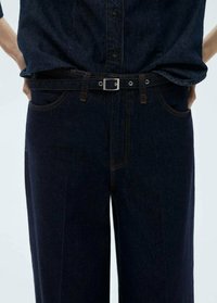 Dark denim jeans with a straight cut, featuring a silver buckle belt, contrasting orange stitching, and front pockets.