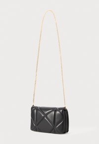 Schwarze gesteppte Leder-Umhängetasche mit goldfarbener Kette, rechteckiger Form und geometrischem Steppmuster. Mit einer Klappe verschlossen.