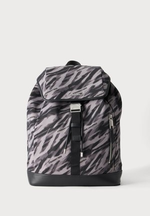 Zaino grigio e nero con motivo, chiusura a patta, cinturino frontale, tasca con zip e piccoli loghi "Karl Lagerfeld" sul tessuto.