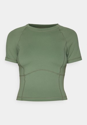 Kortærmet, tætsiddende crop top i olivengrøn med synlige sømdetaljer og rund halsudskæring på en ensfarvet baggrund.