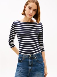 Marineblauw en witte gestreepte longsleeve top gecombineerd met high-waisted denimshorts, voorzien van een knoopsluiting en vijf zakken.