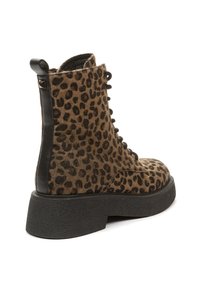 Botín de tobillo con estampado de leopardo y acabado de textura peluda, detalles en cuero negro, puntera redonda y suela gruesa de goma negra.