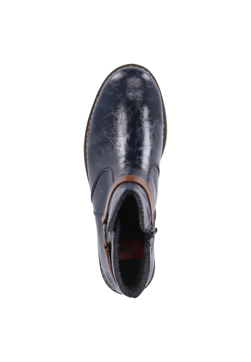 Bottine bleu marine en cuir brillant à texture craquelée, avec une lanière accentuée marron et une doublure intérieure pelucheuse.