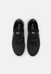 Baskets tricotées noires et grises avec un dessus texturé, des lacets élastiques et une semelle extérieure blanche. Présente le logo PUMA sur le côté et la languette.