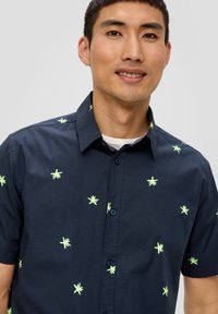 Korte mouwen shirt in donker marineblauwe stof met verspreide groene palmboomborduursels, button-down kraag en een getailleerd ontwerp.