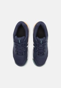 Zapatillas deportivas en color navy con parte superior de malla, acentos de logo en blanco y detalles naranjas en la suela. Presenta cordones tradicionales y cuellos acolchados.