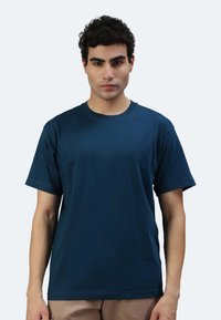 T-shirt in cotone blu navy con maniche corte, scollatura rotonda e una texture liscia. Nessun motivo o grafica visibile.
