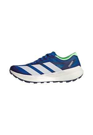 Zapatilla de running Adidas Terrex azul y blanca con forro interior verde, suela negra y "Lightstrike Pro" en la entresuela blanca.
