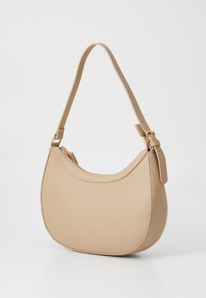 Beige leren handtas met een gebogen vorm, een enkele schouderriem en gouden hardwareaccenten; heeft een ritssluiting aan de bovenkant.