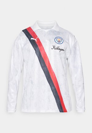 Valkoinen pitkähihaista jalkapallo-paitaa kauluksella, jossa on vino punainen ja musta raita, Puma-logo ja Manchester Cityn tunnus.