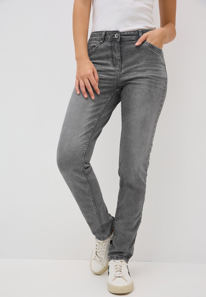 Jeans grigi slim-fit in denim, con tasche anteriori, chiusura a bottone e zip, e dettagli di scolorimento delicati. Abbinate a sneakers bianche.