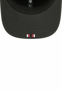 Schwarze Kappe mit flachem Schirm, ausgestattet mit drei kleinen horizontalen Streifen in Rot, Weiß und Schwarz an der Vorderseite. Glatte Stofftextur, minimalistisches Design.