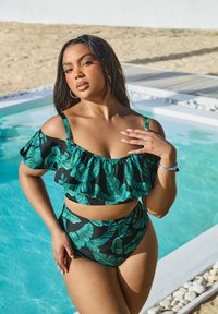 Svart bikini med grönt bladmönster, med en volangtop och högmidjad botten. Slätt tyg med justerbara band.