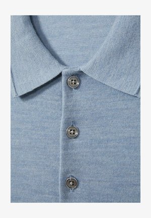 Svijetloplavi pleteni polo majica s teksturiranom tkaninom. Ima klasičan ovratnik i tri metalna gumba sprijeda.