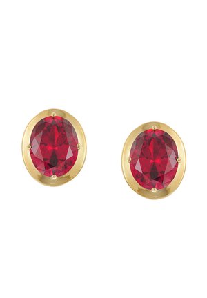 Pair of oval red gemstone stud earrings set in gold bezels on a white background.