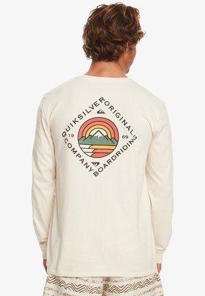 Crème t-shirt met lange mouwen en een grafisch logo met bergen en een regenboogontwerp op de rug. Zachte, gladde stoftextuur.