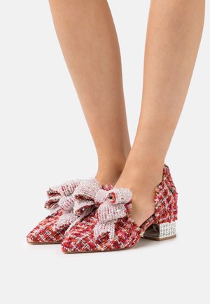 Chaussures à talons hauts en tissu tissé dans des teintes de rose et de rouge, présentant de grands nœuds et des talons blocs scintillants avec des embellissements. Design à bout pointu.