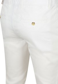 Witte katoenen broek met een gladde textuur, voorzien van achterzakken en een goudkleurige knoopdetails. Klassieke pasvorm en eenvoudig ontwerp.