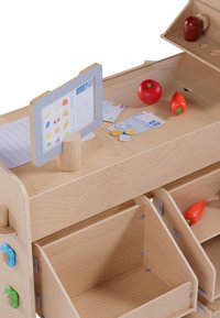 Houten speelgoedkassa met een lichte kleurafwerking, voorzien van een displaypaneel, speelgeld, rode tomaten speelgoed en open opbergvakken.