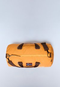 Borsa duffel gialla con strap marroni, chiusura con zip e una toppa con una bandiera. Il materiale appare robusto con una texture liscia.