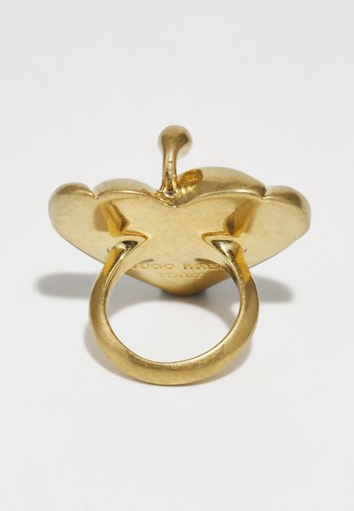 Anello in tono oro con un design a forma di cuore, finitura liscia, un anello centrale sollevato e una banda texturizzata. Iscrizione sulla base.