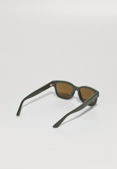 Ochelari de soare din plastic verde închis cu lentile maro, formă pătrată, accent auriu distinctiv la balama, brațe elegante.