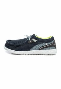 Zapato textil azul marino y gris con suela moteada blanca, puntera redondeada, diseño de cordones y forro interior de color verde brillante.