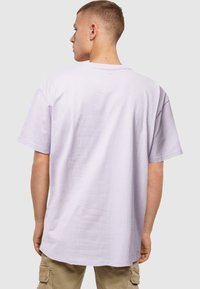 Lyse lilla oversized t-shirt lavet af bomuld, med korte ærmer og rund halsudskæring, i en glat tekstur og en afslappet pasform.