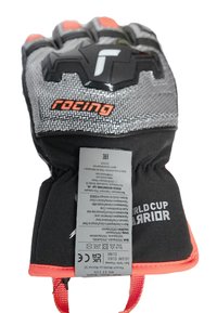 Schwarze und graue technische Handschuhe mit roten Akzenten, strukturierten Handflächen, verstärkten Knöcheln und Pflegeetikett, das innen am Bund angenäht ist.