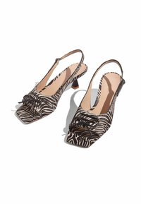 Décolleté con stampa zebra, forma quadrata, in tessuto bianco e nero, con fiocchi decorativi e tacco basso a blocco.