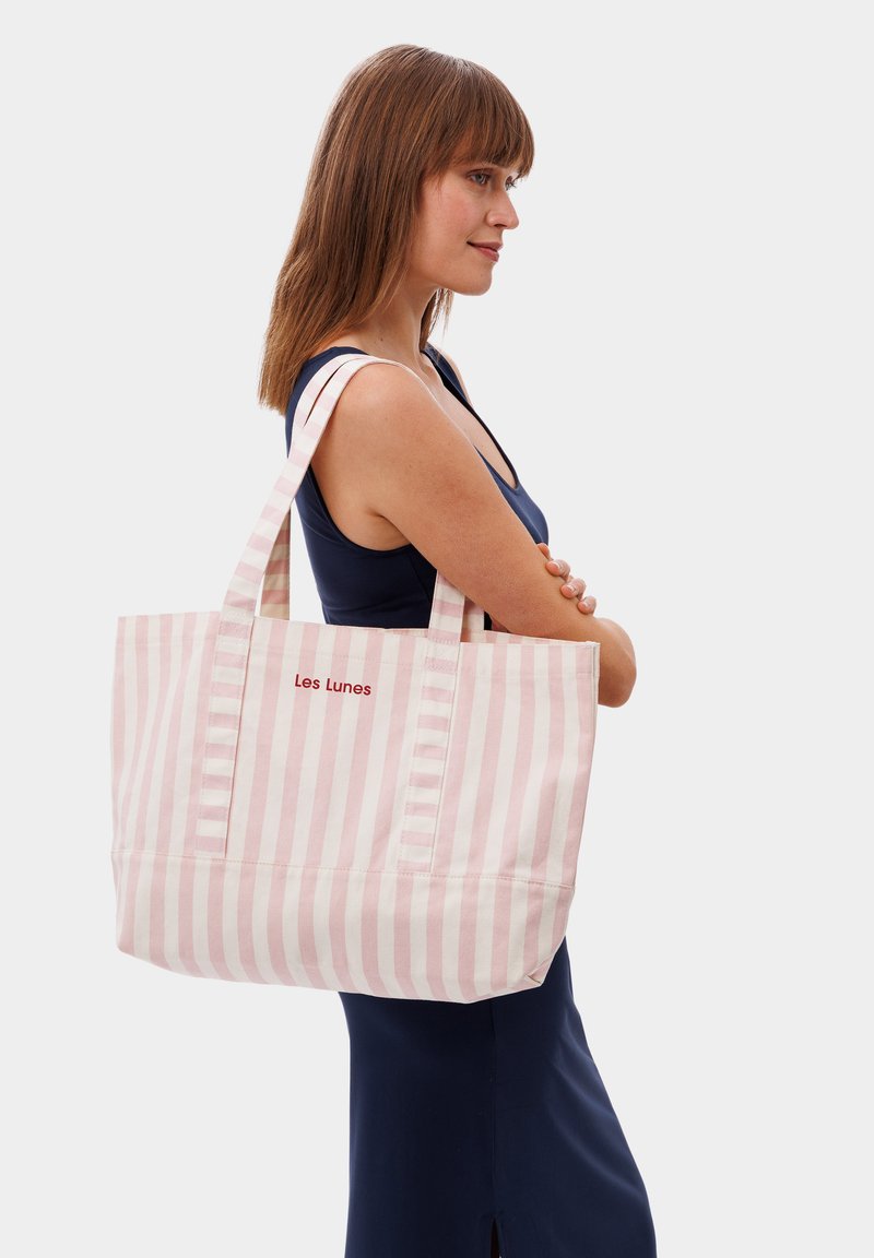 Gestreepte tote bag in roze en wit katoen, met twee stevige handvatten en geborduurd "Les Lunes" logo aan de voorkant.
