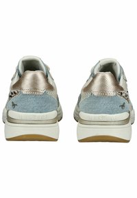 Des baskets en denim et beige métallique présentent un dos texturé, une semelle intermédiaire blanche et une semelle en caoutchouc. Le branding est visible sur le talon.