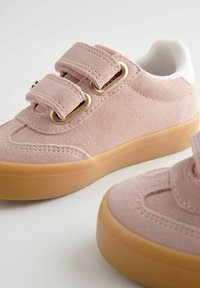 Roze suefne tenisice s teksturiranim završetkom, s dva podesiva čičak-traka, gumene potplate i bijelu tekstilnu oblogu.