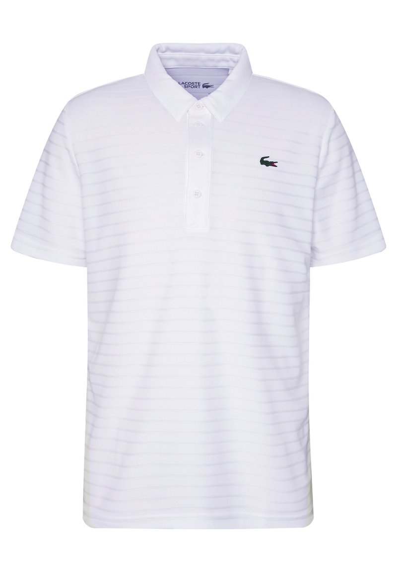 Valkoinen polo-paita, jossa on hienovaraisia vaaka-oraa, lyhyet hihat, kolme nappia sekä kirjailtu vihreä Lacoste-logo vasemmassa rinnassa.