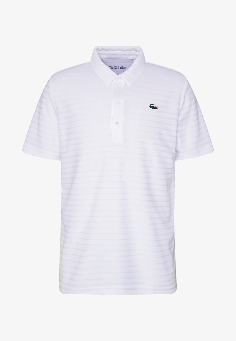 Valkoinen polo-paita, jossa on hienovaraisia vaaka-oraa, lyhyet hihat, kolme nappia sekä kirjailtu vihreä Lacoste-logo vasemmassa rinnassa.