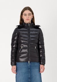Black puffer jacket with a high collar, zip closure, and two front pockets. Features a shiny texture and elastic cuffs.
