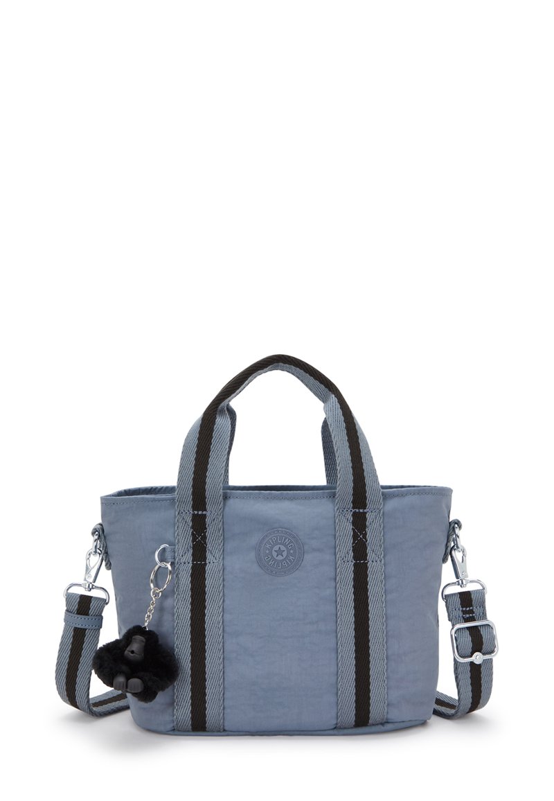 Borsa a tracolla in tessuto azzurro chiaro con manici a strisce nere e grigie, un logo rotondo e un portachiavi a forma di gorilla nero fluffy attaccato.