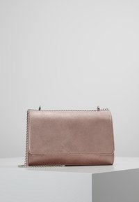Borsa a tracolla in finta pelle rosa dorata con texture, dotata di una tracolla in catena argentata e chiusura flap, caratterizzata da linee pulite e design minimalista.