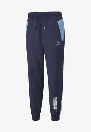 Marineblaue Puma Trainingshose mit hellblauen Seitenpaneelen, elastischem Bund mit Kordelzug, Knöchelbündchen und weißem Grafik-Print am unteren Bein.