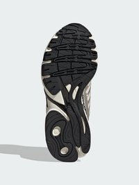 Czarna gumowa podeszwa zewnętrzna z teksturowanymi wzorami chwytającymi i dwoma okrągłymi wycięciami; posiada smukły design z jasnoszarymi akcentami.