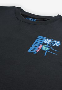 Sudadera de algodón negra con un gráfico en azul y rosa que incluye el texto "STOCKHOLM" y una mano sosteniendo flores. Cuello redondo.