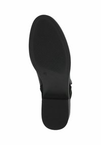 Suela de zapato negra con patrón de agarre texturizado, forma redonda y diseño plano. Presenta un ligero tacón y bordes suaves. Tamaño marcado como 4½.