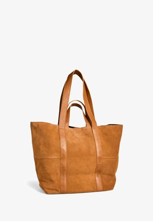 Grande sac tote en daim beige avec deux anses courtes et deux longues en cuir, se tenant debout sur un fond blanc.