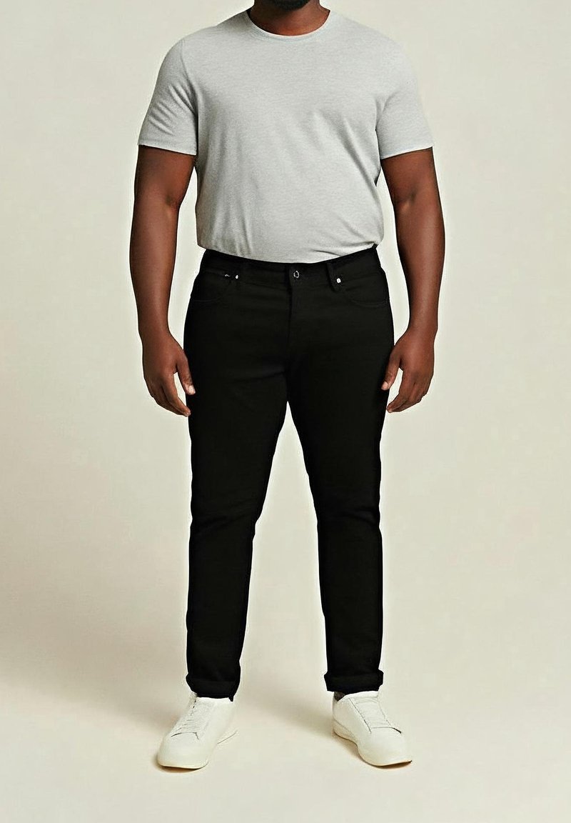 Svarta jeans med smal passform och femficksdesign, kombinerade med en grå t-shirt med rund hals. Avslutat med vita sneakers.