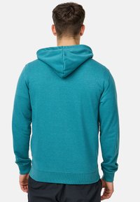 Sweat à capuche teal avec une texture douce, des poignets et un ourlet ajustés. Doté d'une poche kangourou et d'une silhouette décontractée.