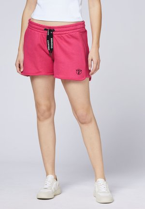 Rosa Fleece-Shorts mit elastischem Bund, verstellbarem Kordelzug und Seitentaschen. Mit einem schwarzen Logo-Emblem auf der linken Seite.
