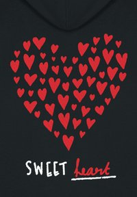 Čierna tkanina s veľkým červeným vyšívaným srdcom vyrobeným z rôzne veľkých srdcičiek; biely text "SWEET" a červený text "heart" nižšie.